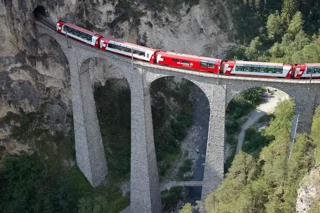 The Glacier Express crossing a stone viaduct in the Alps
