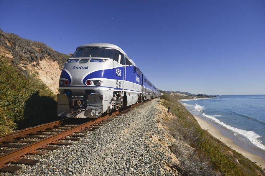An Amtrak locomotive leading the Coast Starlight along a cliff above the surf