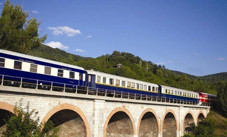 The blue and cream Golden Eagle Danube Express crossing a stone viaduct
