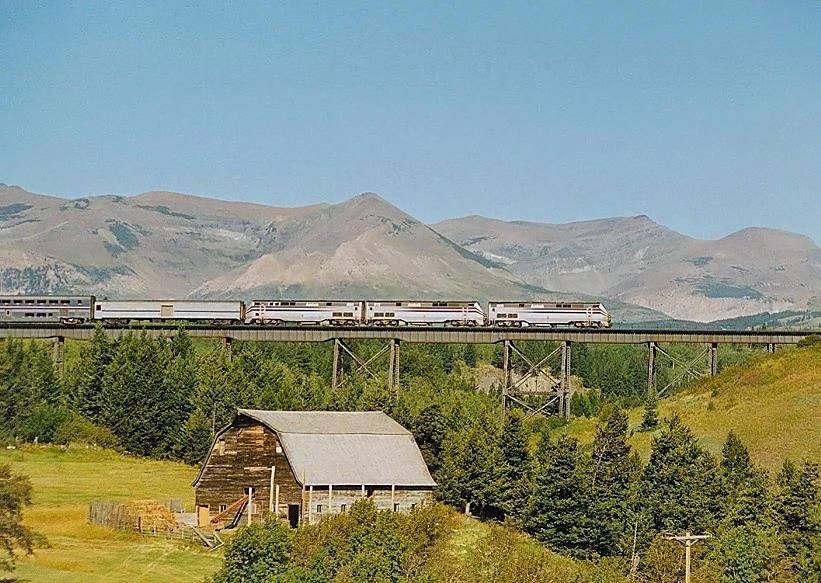 The Empire Builder crossing a trestle with bare mountains behind