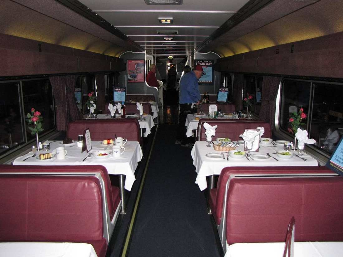 A Superliner dining car with white tablecloths and booths