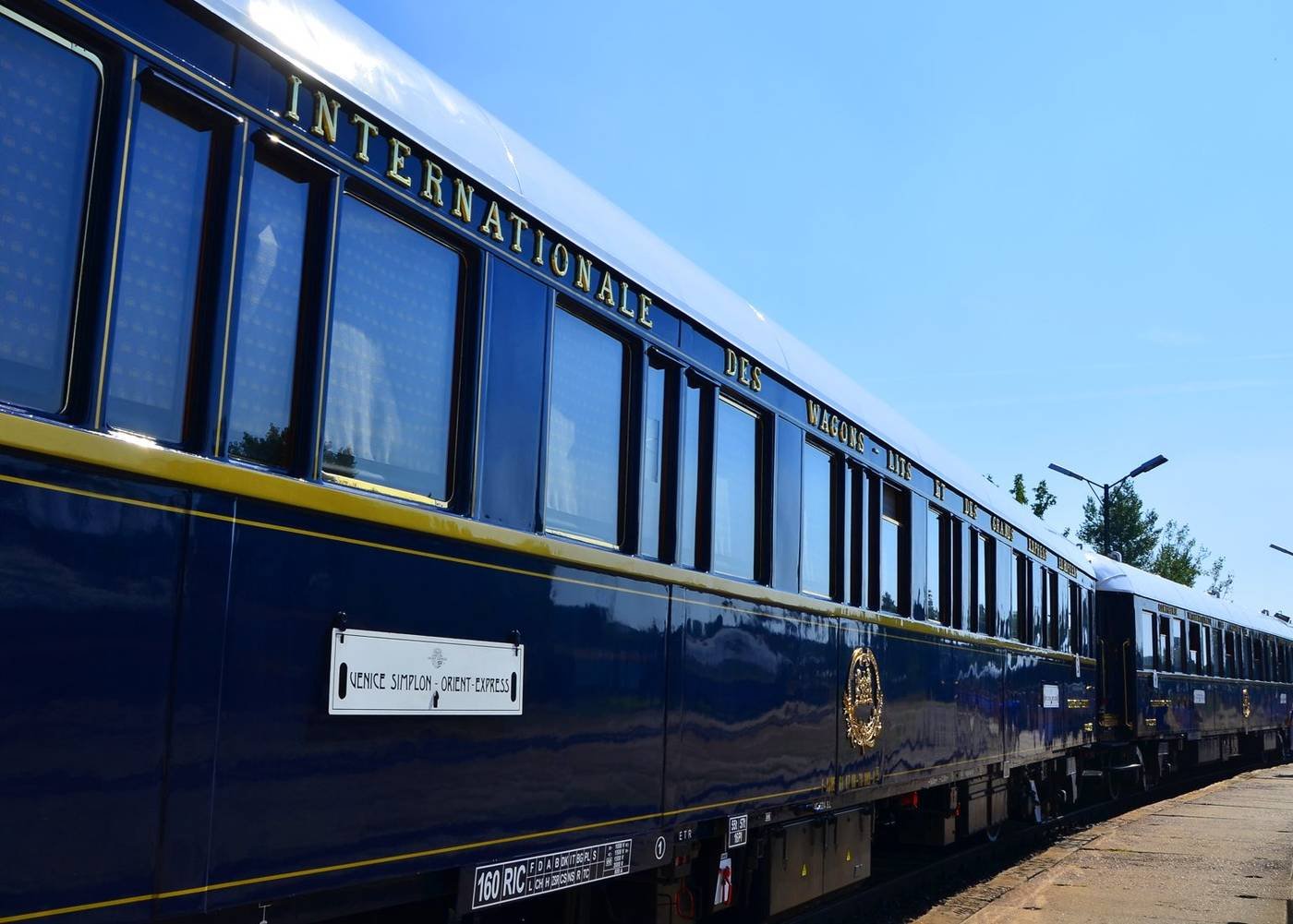 A navy Venice Simplon-Orient-Express carriage with gold lettering and the train’s nameplate