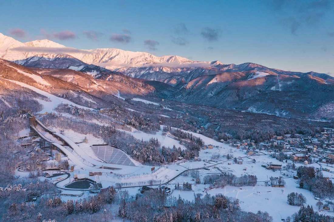 Snowy peaks of the Hakuba Valley above the village and ski jumps