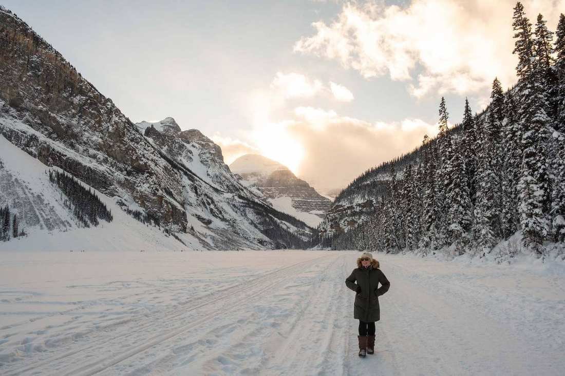 Frozen Lake Louise with snow-covered peaks behind it