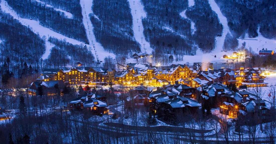 The ski village at Stowe, Vermont, lit at dusk beneath the trails