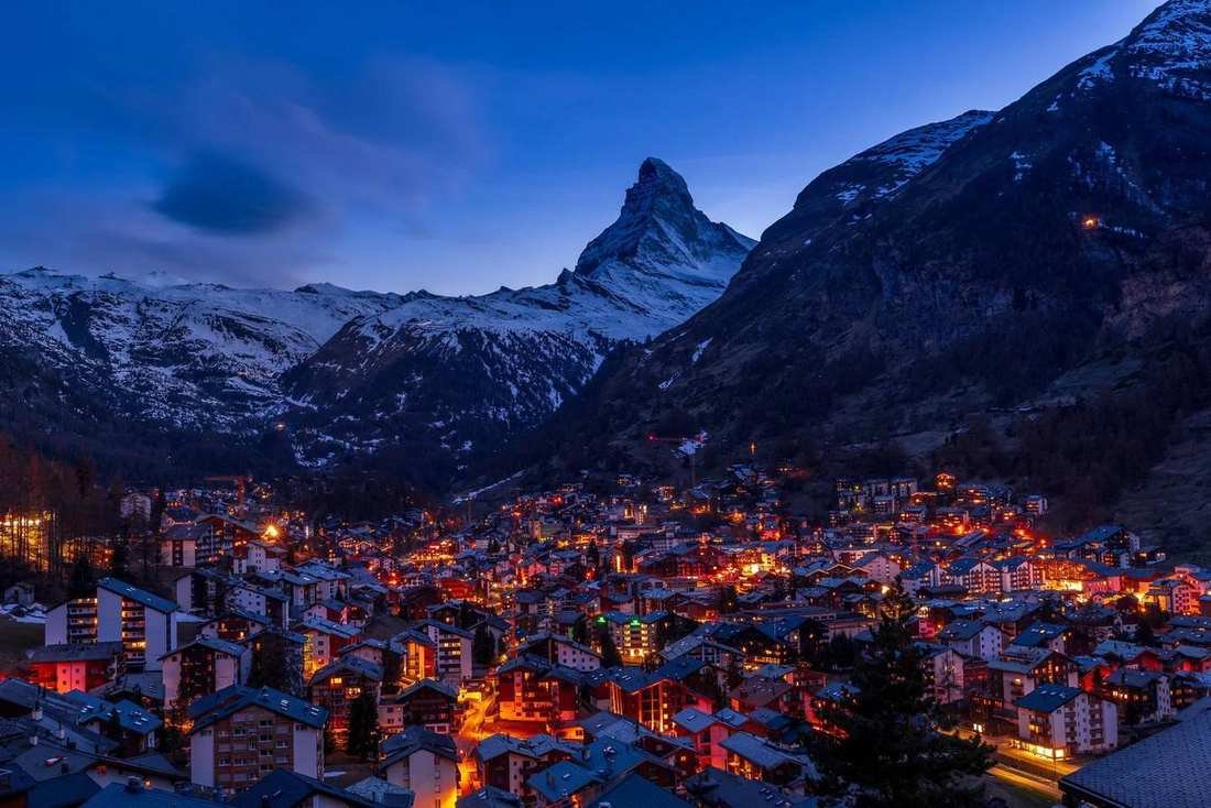 Zermatt at dusk, with the Matterhorn above the lit village